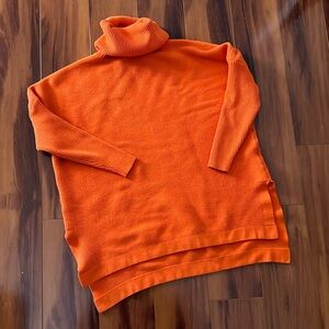 Amazon orange turtleneck sweater, three-quarter length sleeves.